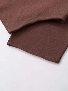 Detailed macro view of the fine ribbed texture and overlock stitching on a brown knit shawl