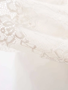 Macro shot of delicate white floral lace fabric detail with intricate crochet patterns