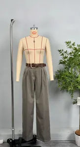 Detail shot of taupe high-waisted wide-leg trousers with brown leather belt and gold buckle