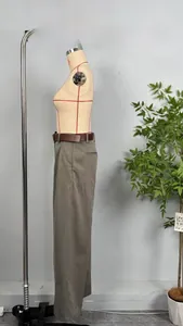 Close-up of taupe high-waisted wide-leg trousers with a brown leather belt detail