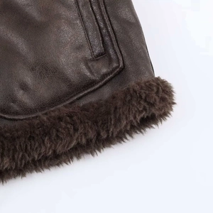 Detail of the high-quality brown leather texture and plush wool lining on a flight jacket