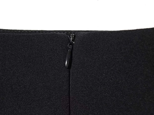 Detail eines verdeckten Reißverschlusses an schwarzer strukturierter Bluse mit feiner Naht