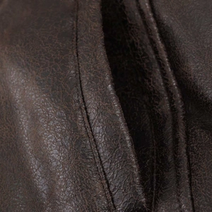 Detailed macro view of vintage dark brown faux leather jacket with reinforced stitching