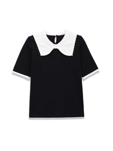 Detail of contrast Peter Pan collar on black ribbed knit top with wavy edges