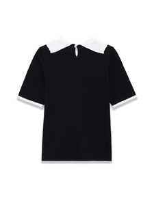 Detail of a slim fit black knit top featuring a white Peter Pan collar and ribbed texture