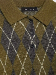 Détail du col polo en maille à losanges avec trois boutons et étiquette de marque