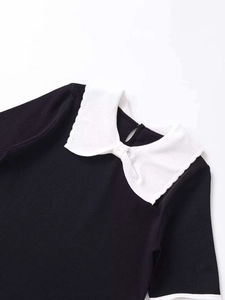 Detail of knit top with contrast white bow collar and water-drop button closure