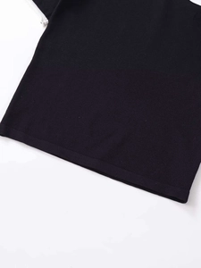 Close-up of the dense knit fabric texture and high-quality hem finishing of a slim sweater