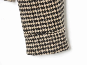 Detailed close-up showing the premium houndstooth texture and stitching of the jacket fabric