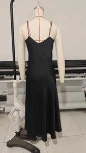 Detail of minimalist black satin slip dress with thin straps and V-neckline on a mannequin