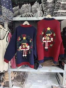 Détail d'un pull en maille avec un ours de Noël 3D en peluche et broderie festive
