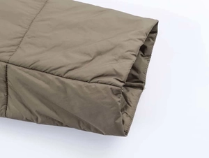 Detail of parallel quilting and texture on the brown nylon sleeve of the puffer jacket