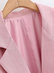 Detail view of pink blazer lapel showing textured fabric and silky smooth inner lining