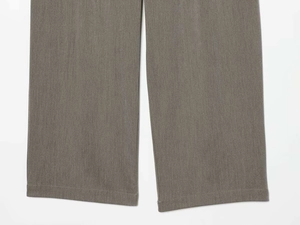 Close-up of wide leg grey trousers showing fine heathered texture and clean hem stitching