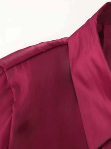 Detail of dark magenta shirt showing shoulder pleats and subtle lustrous fabric texture