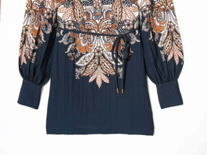 Detailed view of paisley print dress with lantern sleeves and adjustable waist tie