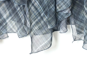 Detail of blue plaid fabric with fine mesh texture and ruffled edge stitching