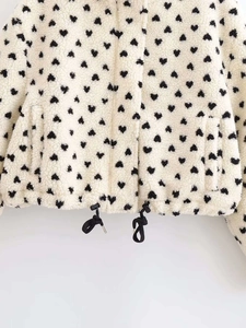 Close-up of heart pattern sherpa fleece jacket with adjustable black drawstring hem detail