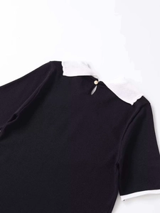 Detail of knit top featuring a white Peter Pan collar and a gold back button closure