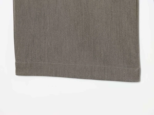 Detailed macro view of high-waist wide-leg trousers hem with fine twill fabric texture