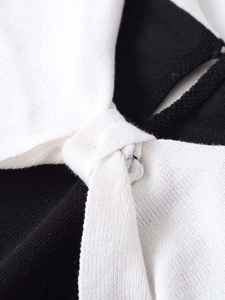 Detailed view of the contrast knot design and texture on a slim knit top