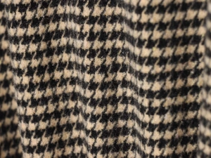 Macro shot of houndstooth wool fabric texture on a vintage style bomber jacket