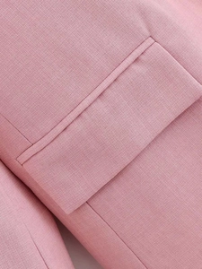 Detailed macro view of the stitching and woven texture on a pink blazer pocket