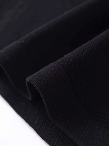 Close-up of black knit fabric showing fine texture and ribbed cuff craftsmanship detail