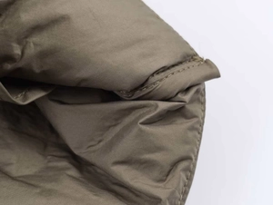 Detailed macro view of olive green quilted fabric showing fine stitching and texture