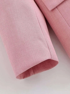 Close-up of pink blazer sleeve showing high-quality woven fabric and neat stitching