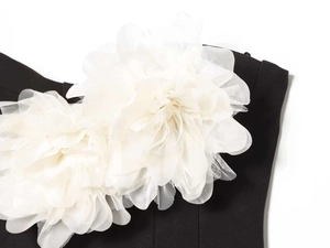 Détail de fleurs 3D en résille blanche sur une robe d'été noire sans bretelles