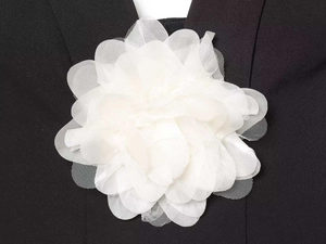 Détail d'une applique florale en mousseline blanche multicouche sur vêtement noir