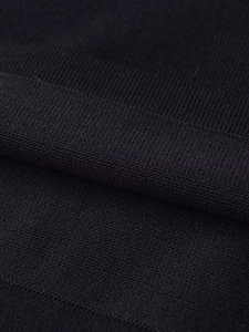 Macro shot of black knit fabric featuring ribbed texture and delicate honeycomb mesh weave