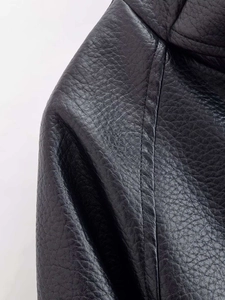 Detailopname van zwart kunstleren jack met dubbele stiksels en fijne leertextuur
