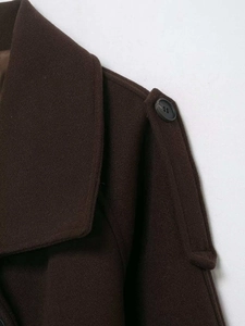 Detail of dark brown wool jacket featuring structured lapel and shoulder epaulet with button