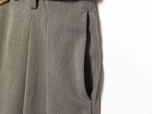 Detail of taupe wide-leg trousers showing belt loops and side pockets texture