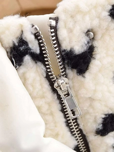 Macro detail of high-density fleece jacket with cow print and quality silver metal zipper