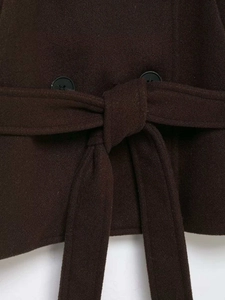 Detail of dark brown wool coat showing waist belt tie and decorative black buttons