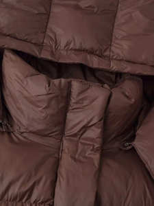 Detail of coffee brown quilted winter jacket showing the hood and nylon zipper closure