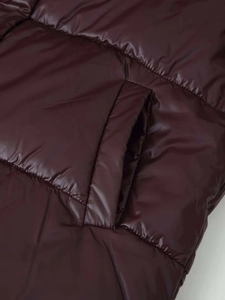 Detailansicht der weinroten Steppjacke mit horizontalen Nähten und Seitentasche