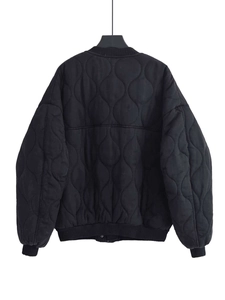 Rear view of black quilted bomber jacket with gourd pattern and ribbed cuffs