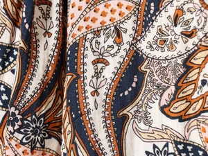Detailed macro shot of bohemian paisley print on high-quality fabric shirt dress