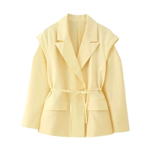 Détail du blazer jaune clair avec col superposé et ceinture ajustable à nouer à la taille