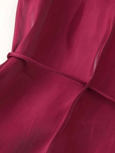 Detail view of deep magenta translucent fabric with silk gloss and fine stitching lines