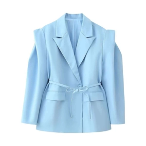 Détail du blazer bleu clair avec épaulettes structurées et ceinture assortie à la taille