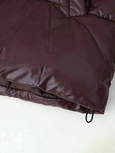 Detail des glänzenden dunkelbraunen Pufferjacke-Saums mit Kordelzug-Stoppern