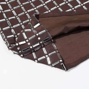 Dettaglio del tessuto a rete marrone con motivi geometrici quadrati in strass