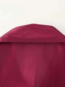 Detail of burgundy glossy shirt showing semi-transparent fabric and fine stitching