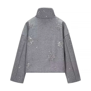 Detail der silbernen Pailletten-Schneeflocken auf grauer Wollmischjacke hinten