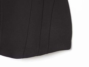 Détail macro du tissu noir montrant les coutures précises et la structure verticale